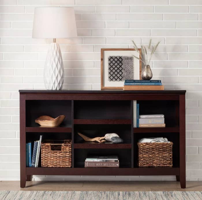 A brown wooden horizontal bookcase with four open shelves