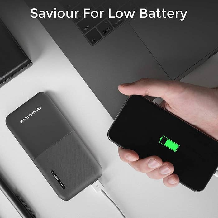 A grey power bank next to a laptop