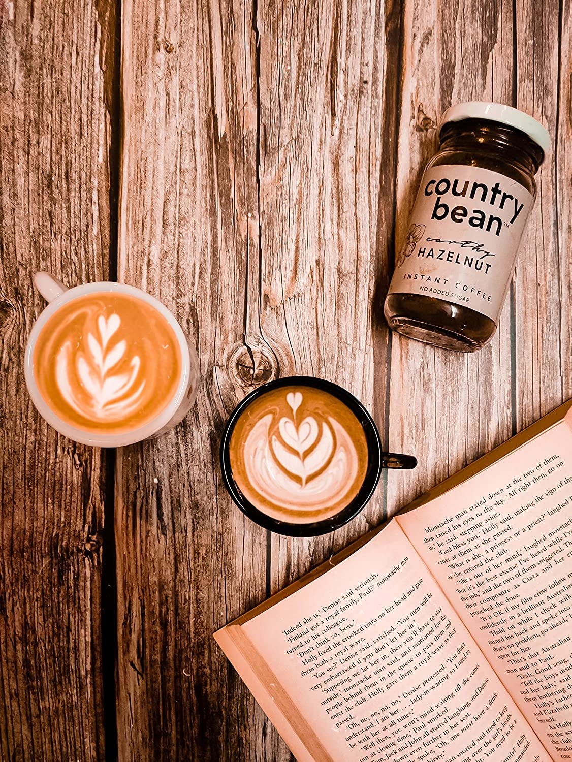 Two cups of coffee pictured with a book.