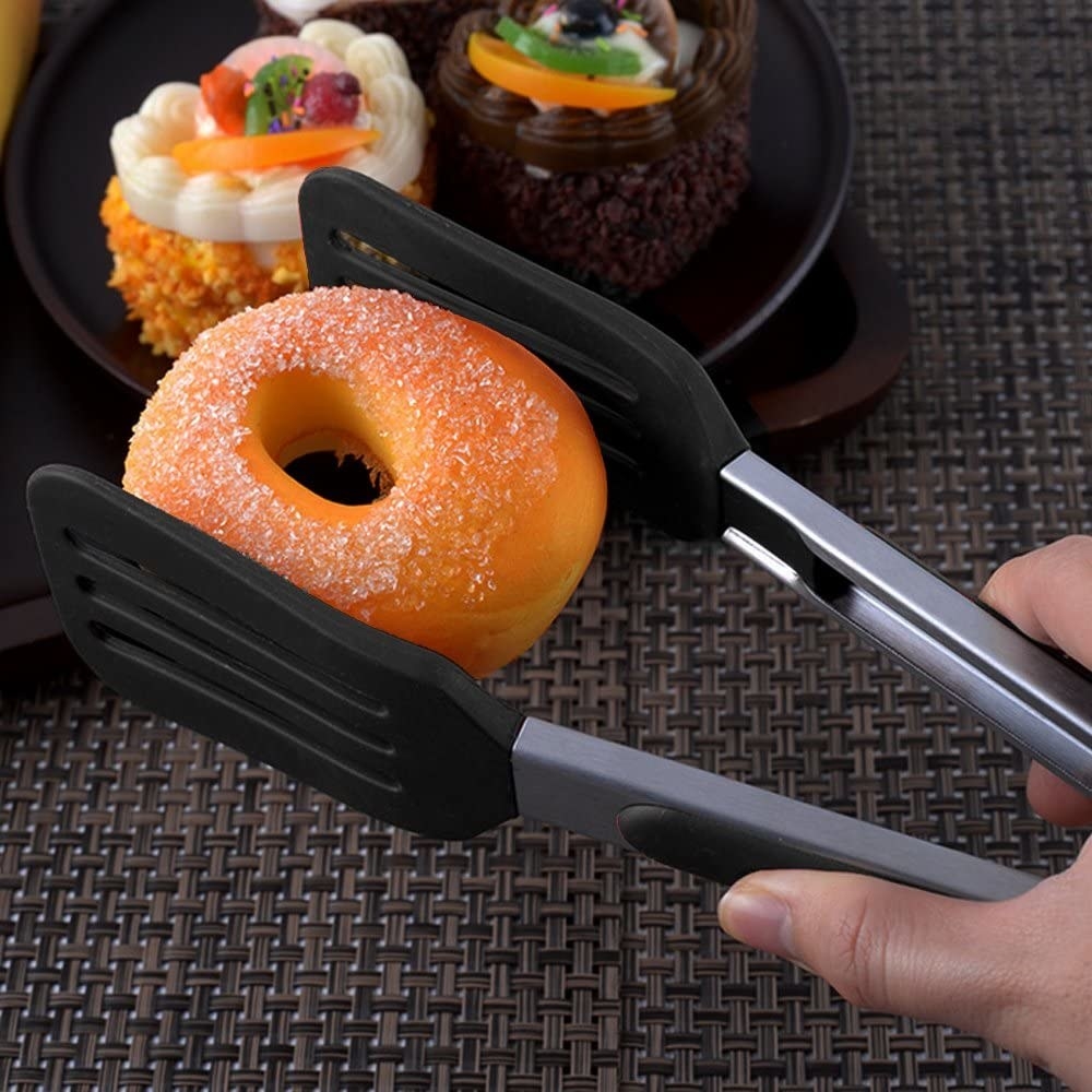 person grabbing a donut with the tongs