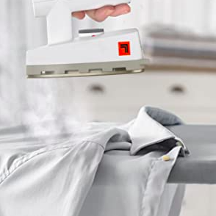 A person applying the steam iron to a wrinkly shirt