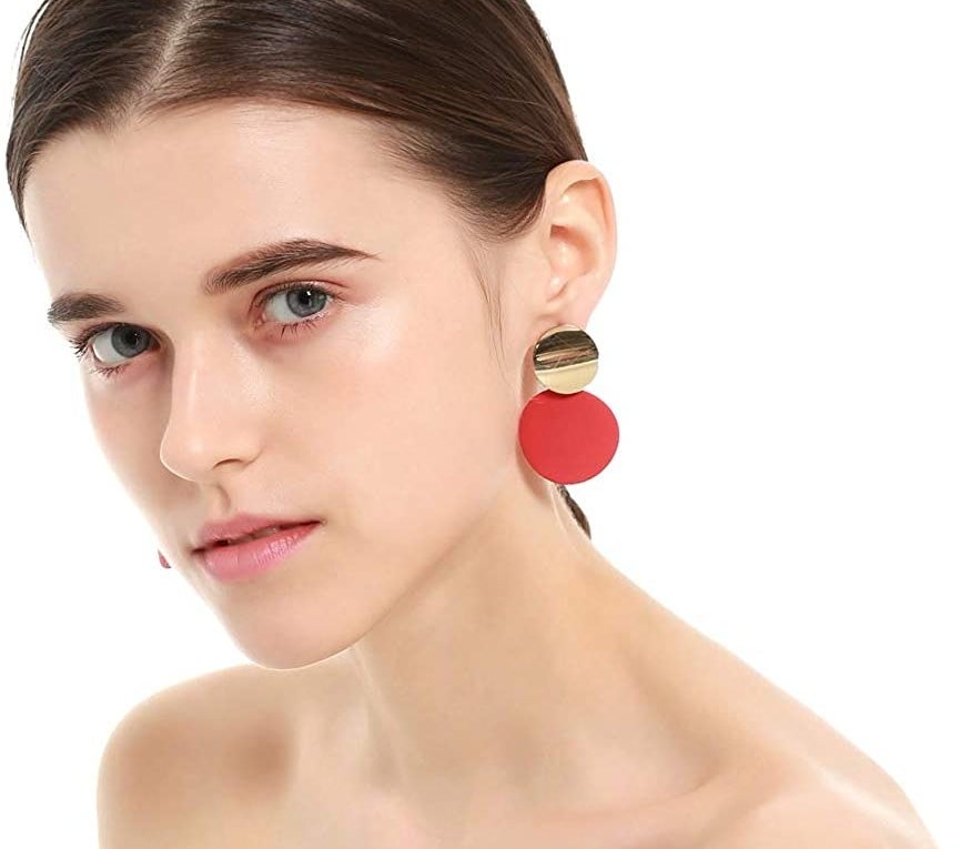Earrings with gold circular stud and dangling matte red disc