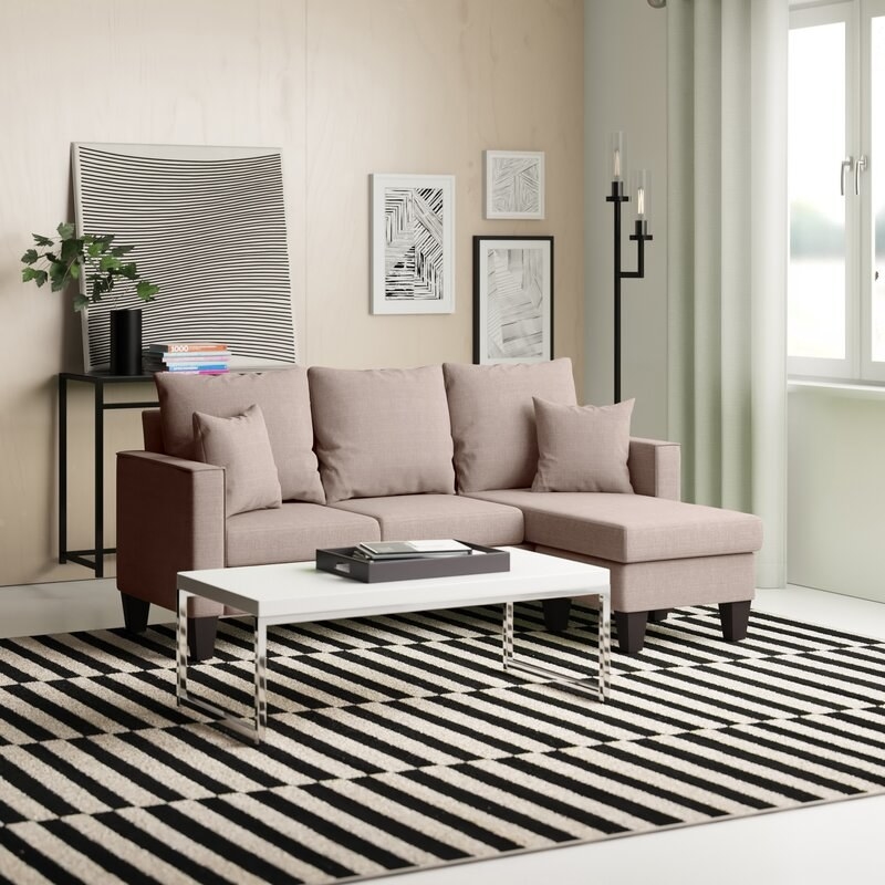 a grey fabric sectional couch in a living room