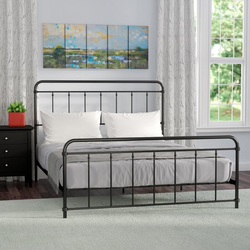 a black metal bed frame with a black metal headboard and footboard