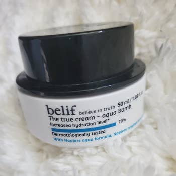 A reviewer's photo of the white and black moisturizer container