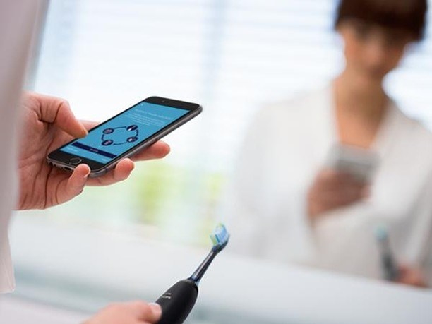 A person using the app while holding the toothbrush