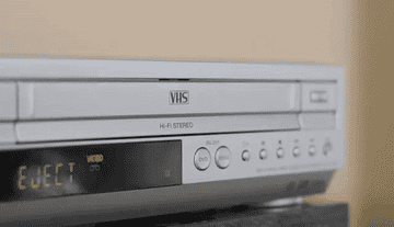 A GIF of someone ejecting a video from a VCR