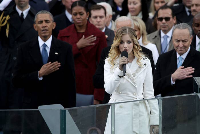 Former President Barack Obama, First Lady Michelle Obama, and Senator Chuck Schumer hold their hands over their hears as Jackie Evancho sings