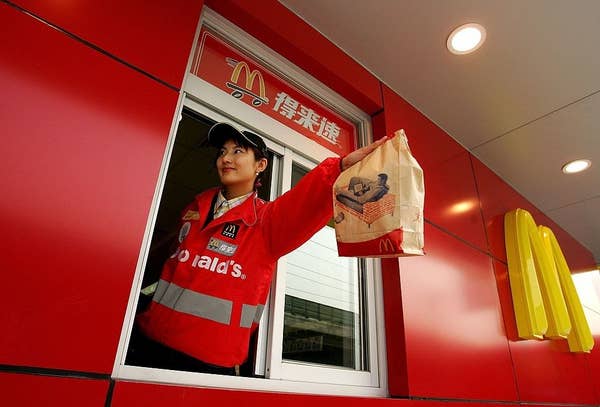 A McDonald's employee hands out food as she waits on customers at their new drive-thru facility on January 19, 2007 in Beijing, China