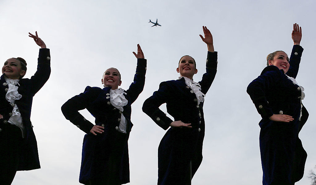 Members of The American Tap Company posing as a plane flies in the distance