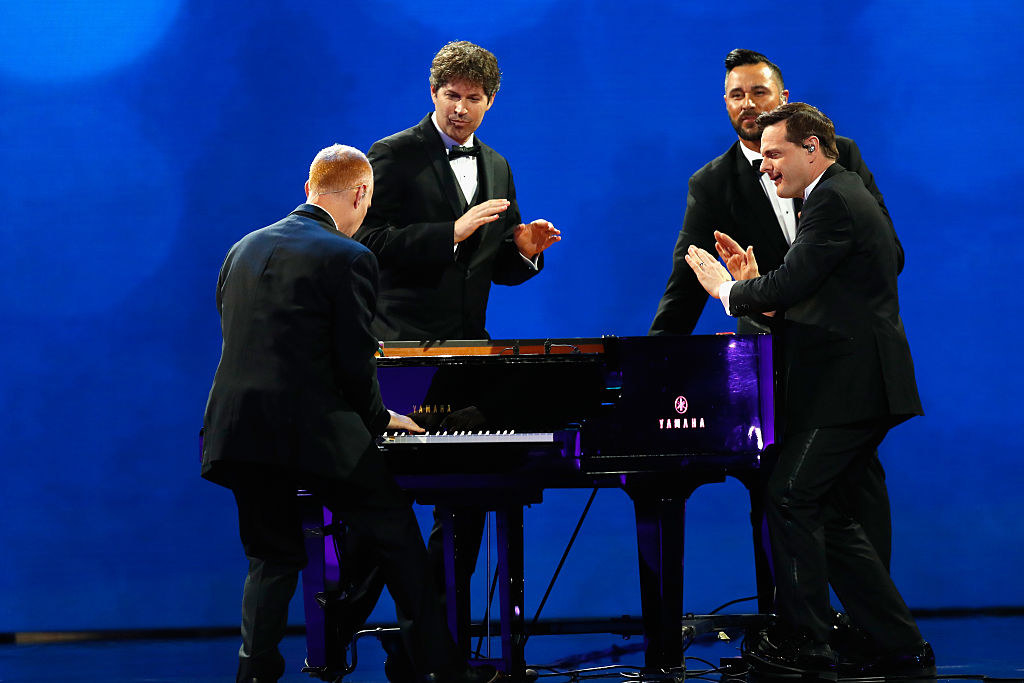 The Piano Guys performing around a single piano