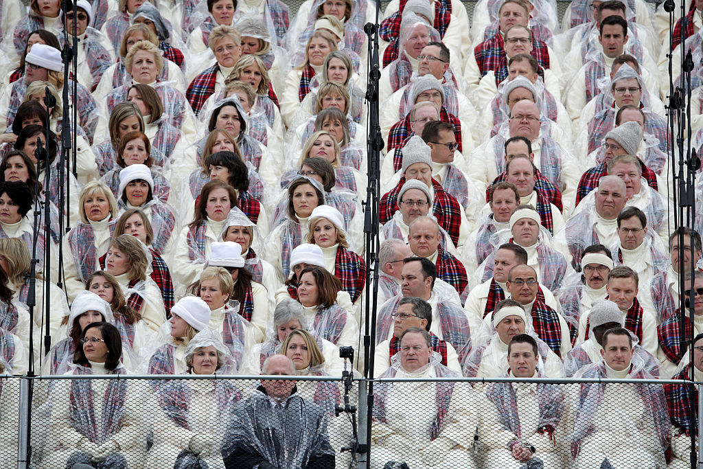 The Mormon Tabernacle choir sits in plastic rain ponchos