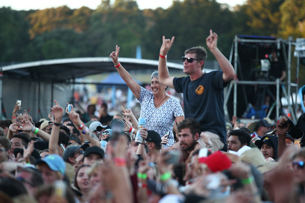 Two people sitting on other&#x27;s shoulders dancing to the music