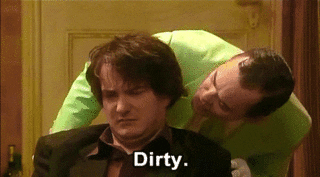 Man leaning over another man whispering the word &quot;dirty&quot; in their ear