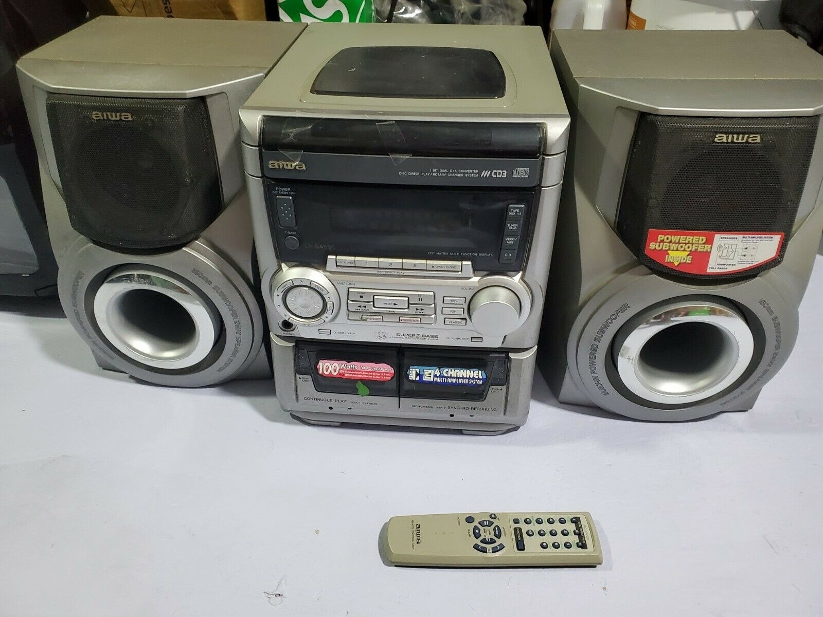 A 3-CD boombox with a remote next to it