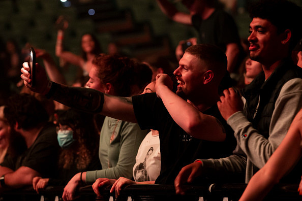 A man taking a selfie at a concert