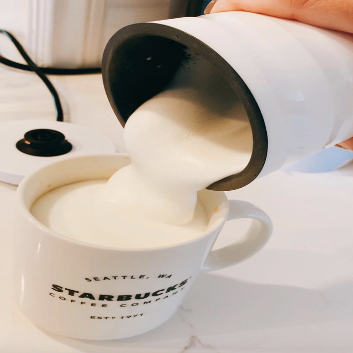 reviewer pouring foamy milk into cup 