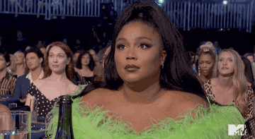Lizzo shrugging her shoulders at an awards show
