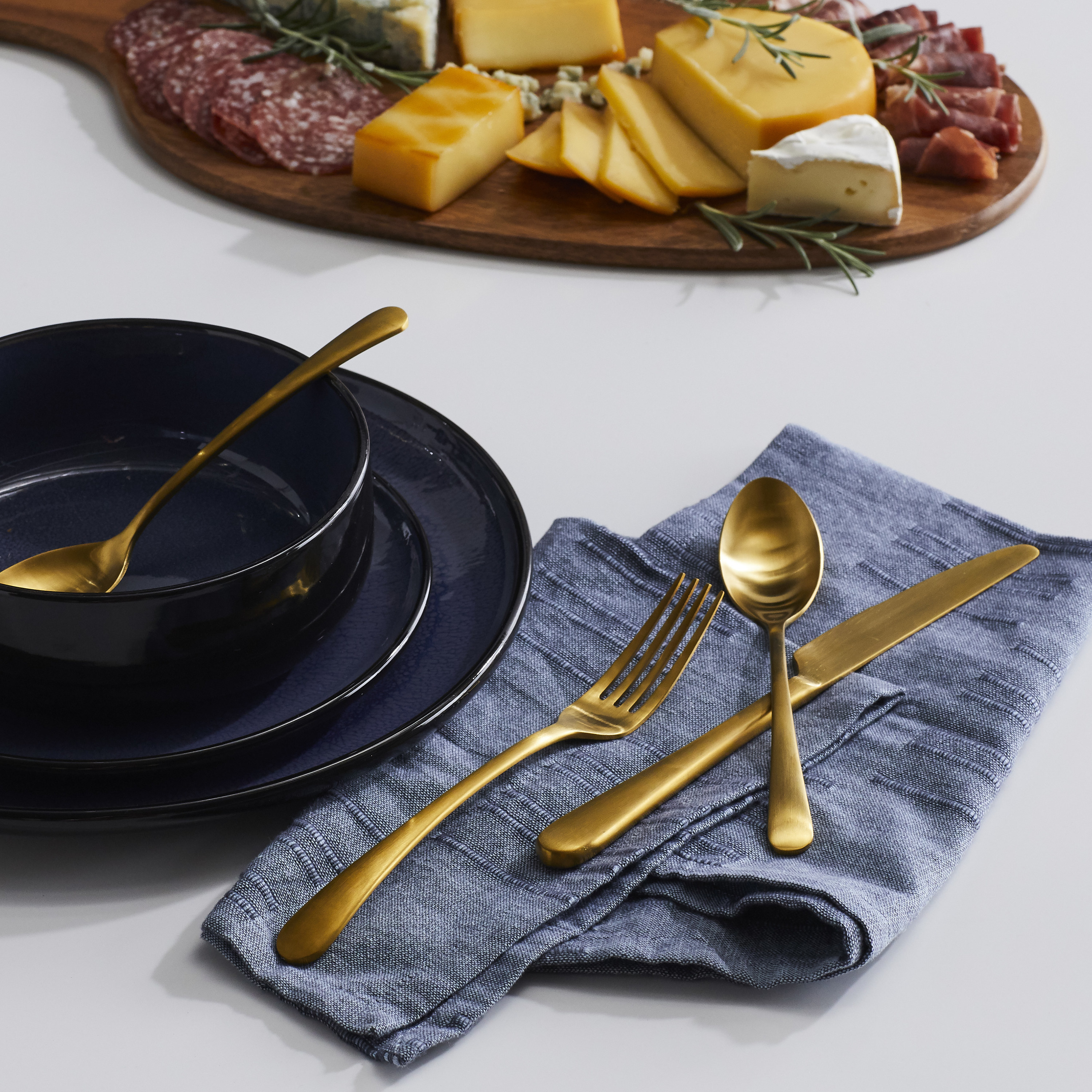 The gold flatware with blue napkins and tableware