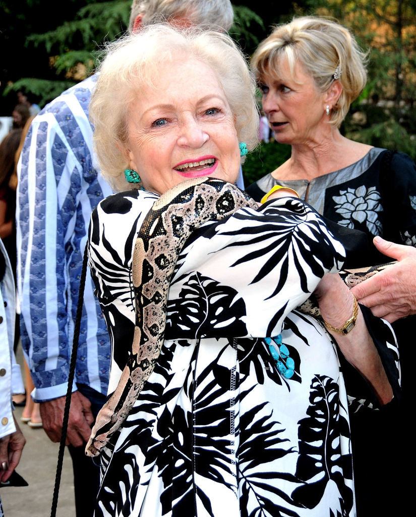 Betty White fearlessly holding a snake over her shoulder