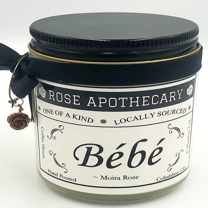 The candle with "ROSE APOTHECARY" branding and the phrase "Bébé" attributed to Moira Rose