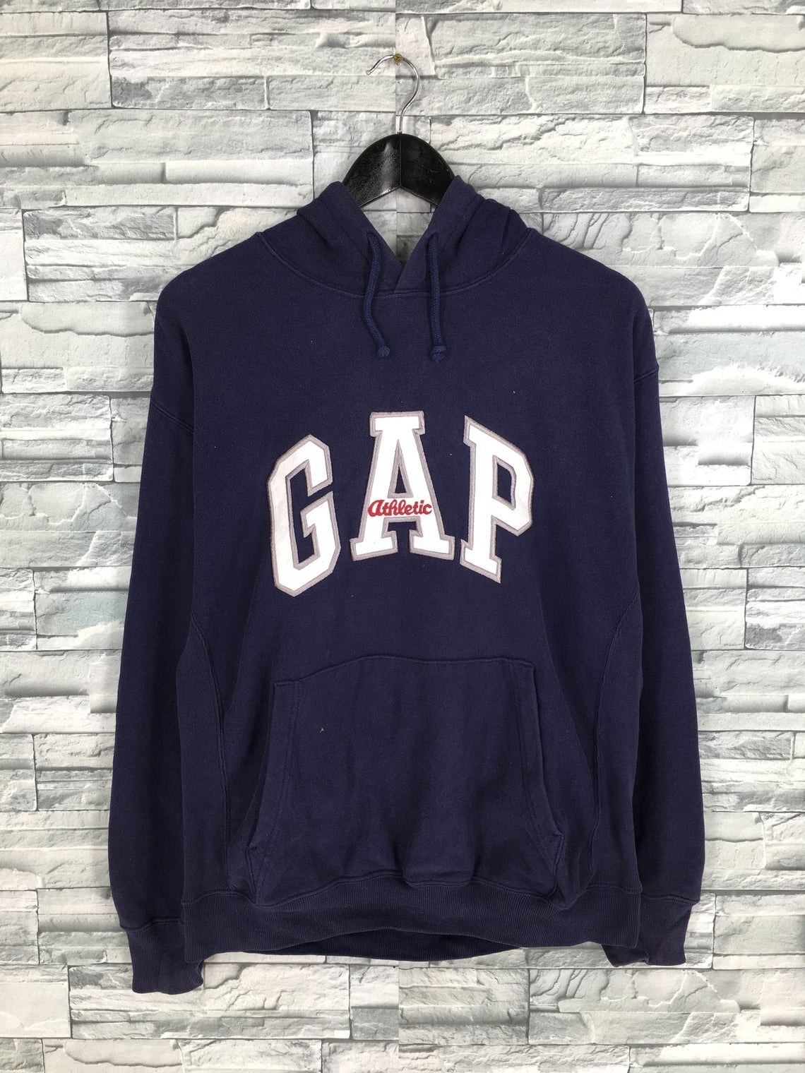 A navy Gap hoodie with Gap athletic embroidered on the chest