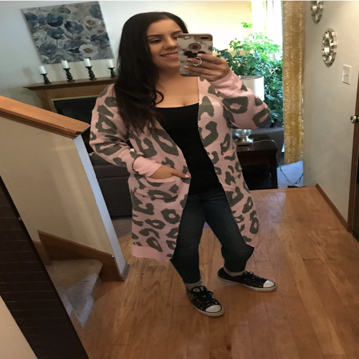 a reviewer wearing the animal print cardigan in pink and grey