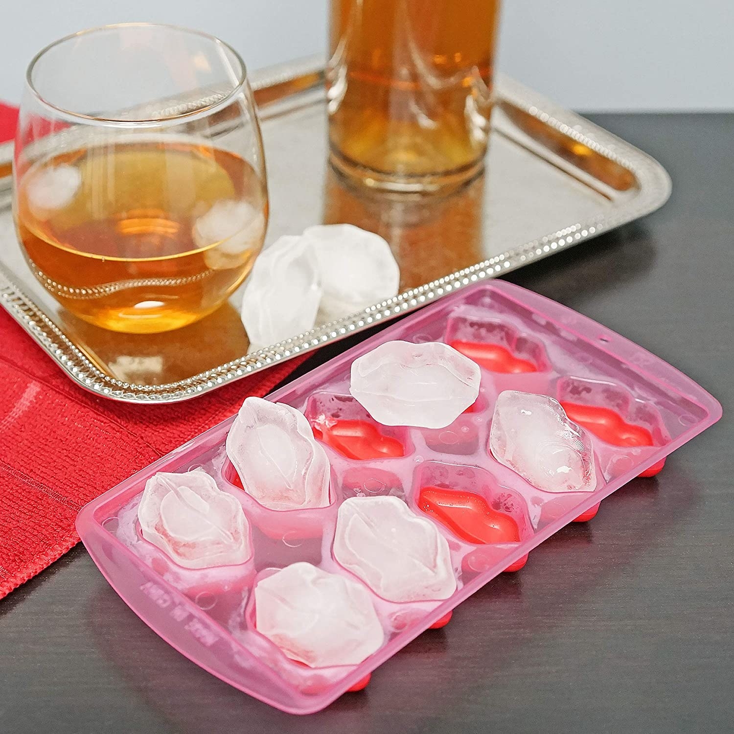 Kiss-shaped cubes in the tray next to a cocktail