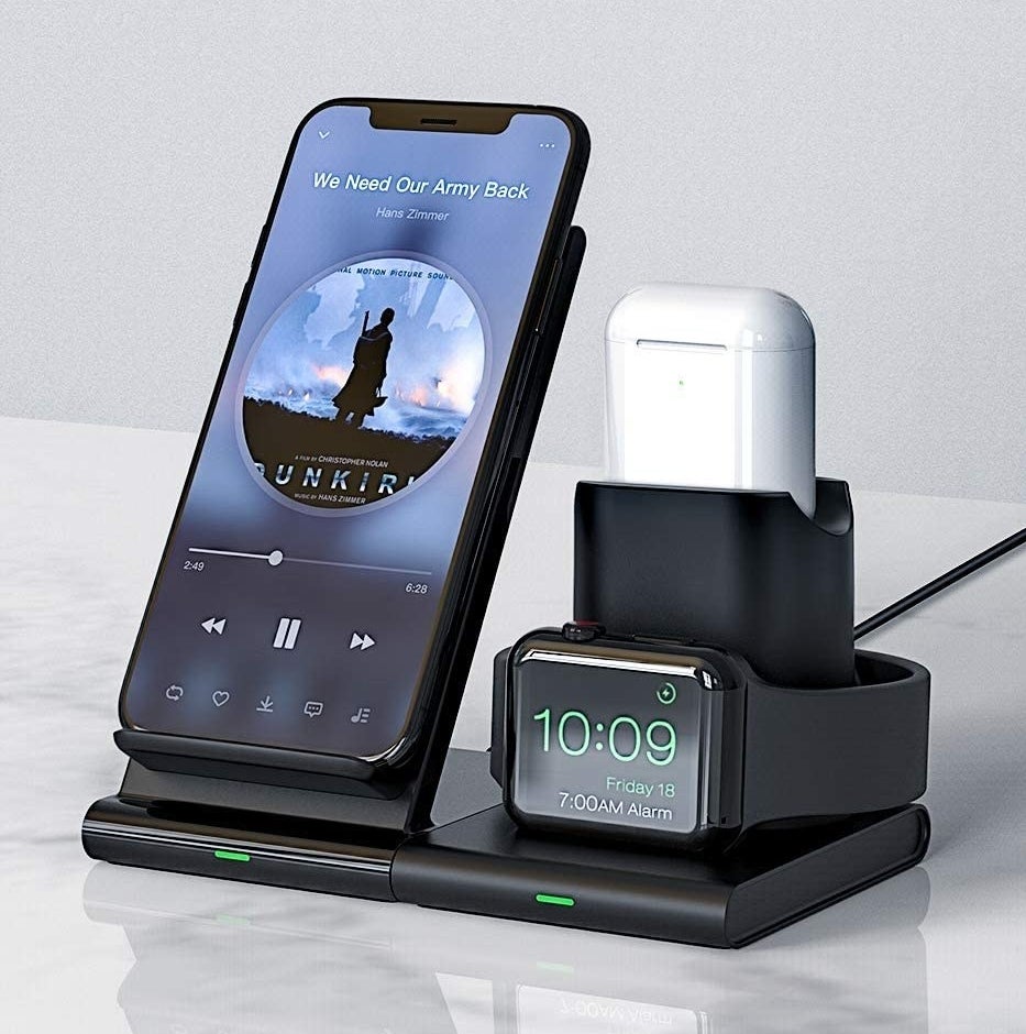 A phone, watch, and earbuds on the charging station