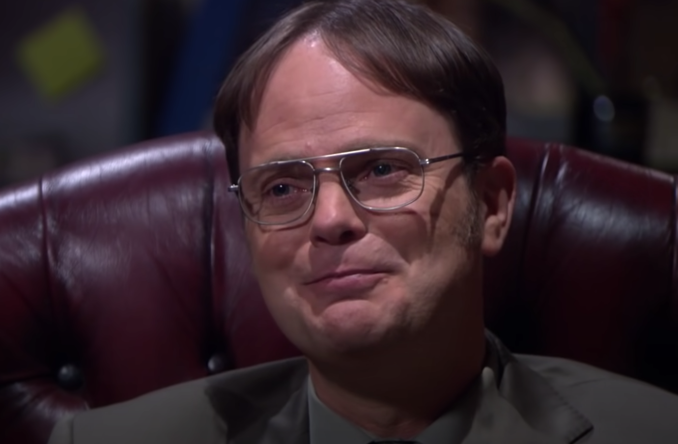 Dwight smiles in his chair