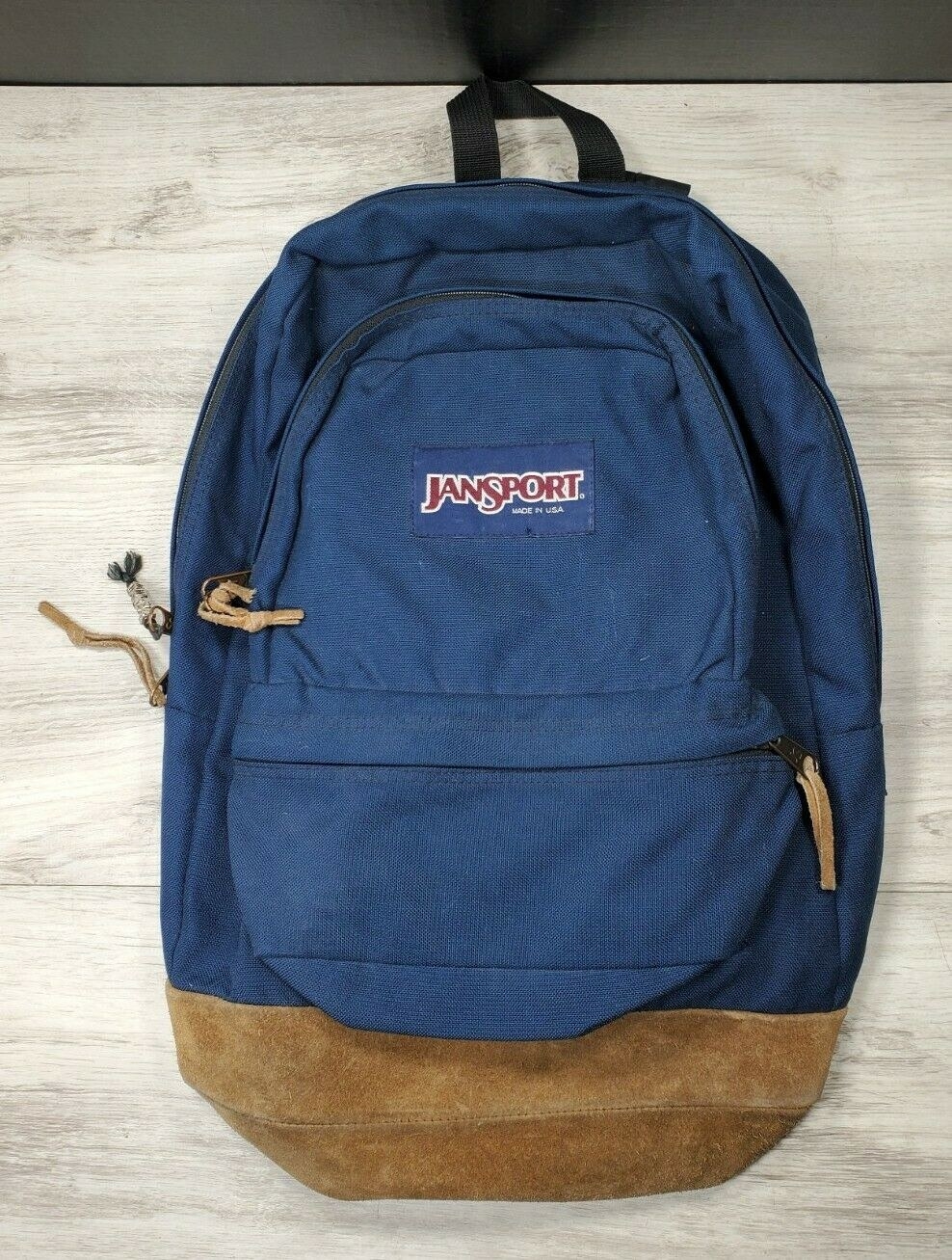 A navy JanSport backpack with a suede bottom