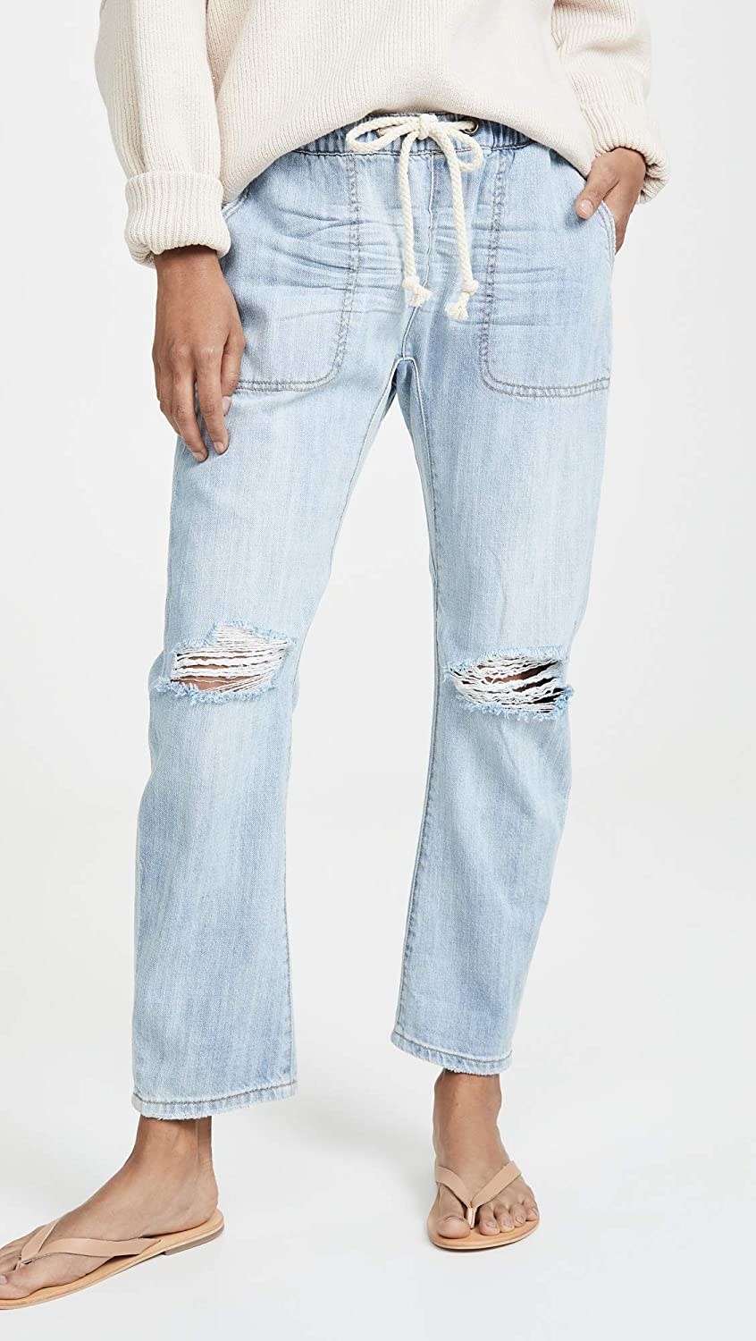 Model wearing the ripped light wash jeans with large front pockets