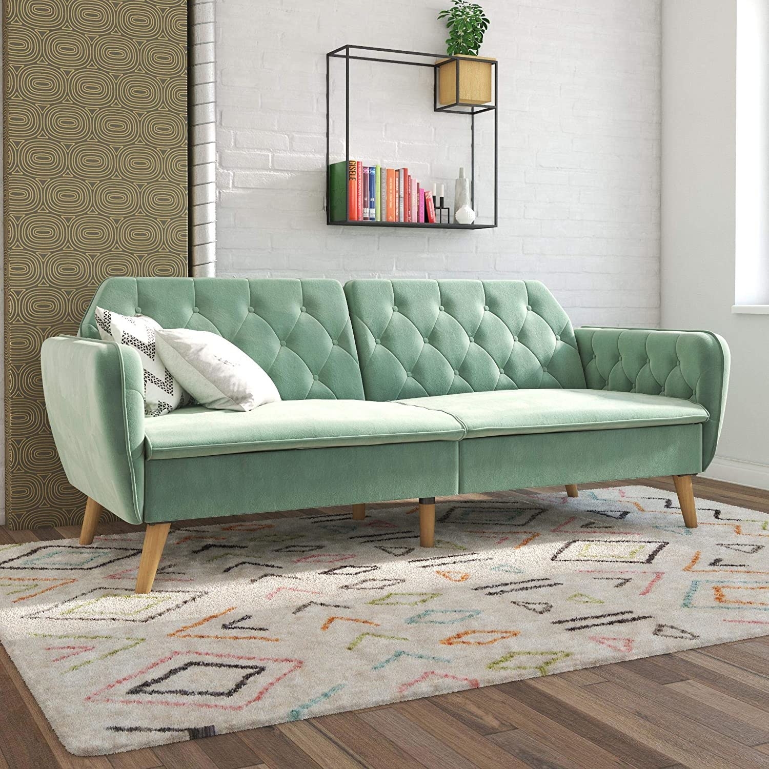 a mint velvet couch with a tufted back
