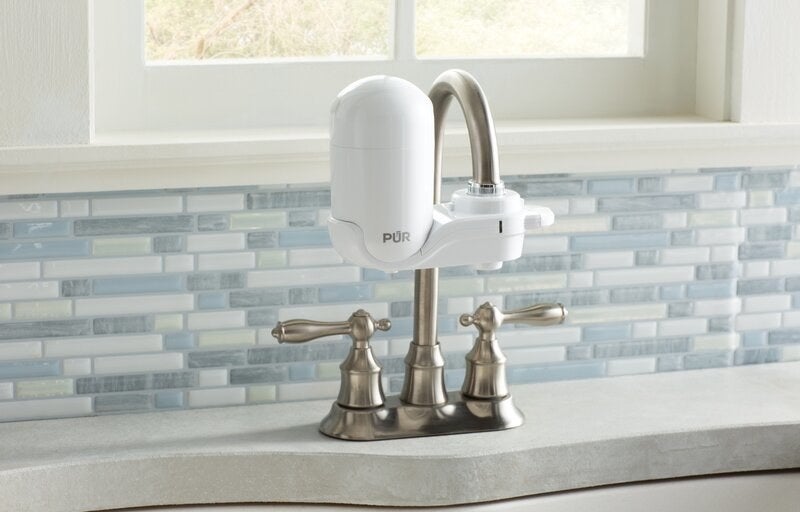 a white water filter attached to a faucet in a kitchen
