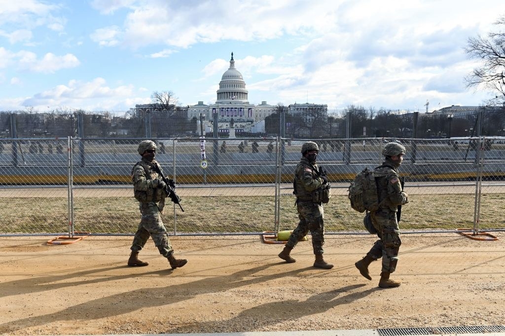 National Guardsmen patrolling the Capitol perimeter with weapons