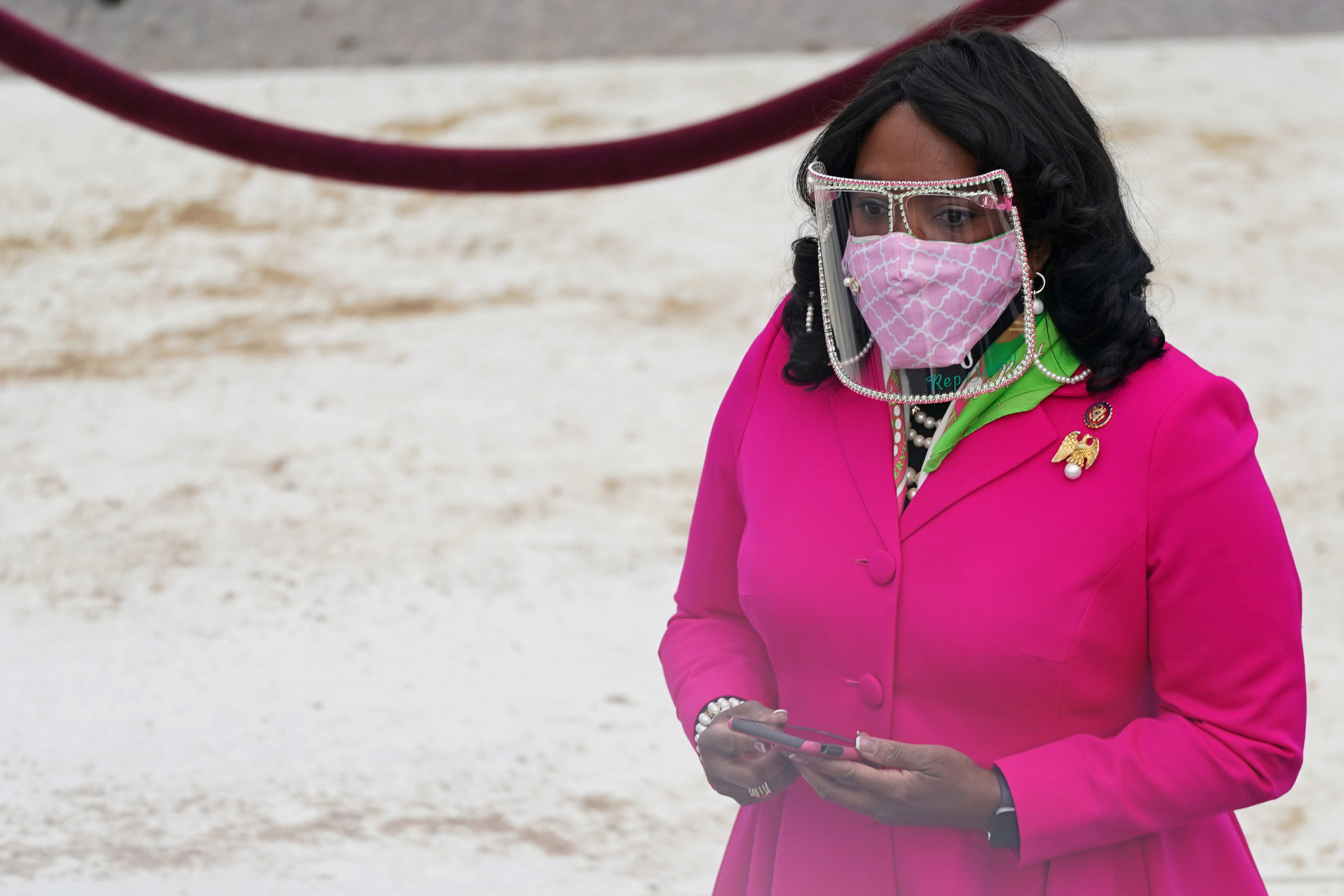 Rep. Terri Sewell in a pink coat, pearl-studded face shield and pink face mask at the inauguration. 