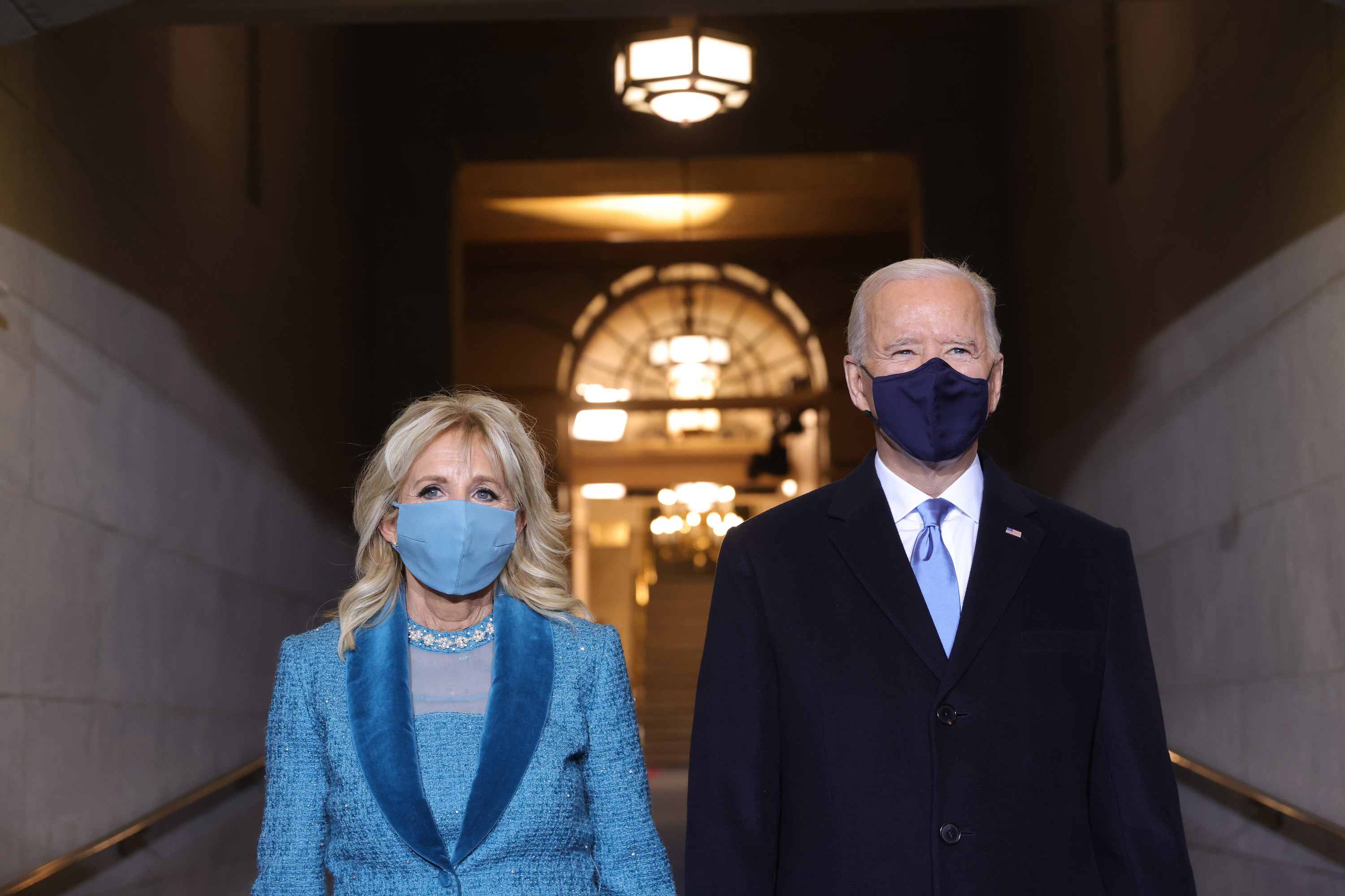 U.S. President Joe Biden with a face mask and Jill Biden with a blue face mask standing on the West Front of the U.S. Capitol on January 20, 2021 in Washington, DC. during today&#x27;s inauguration ceremony. 