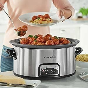 A model scooping meatballs out of the crockpot 