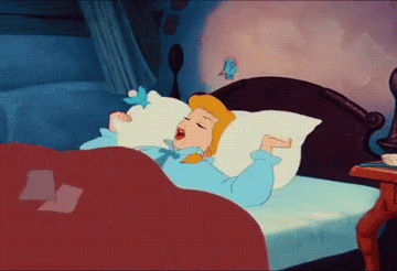 Cinderella rolling over in bed with a pillow over her head 