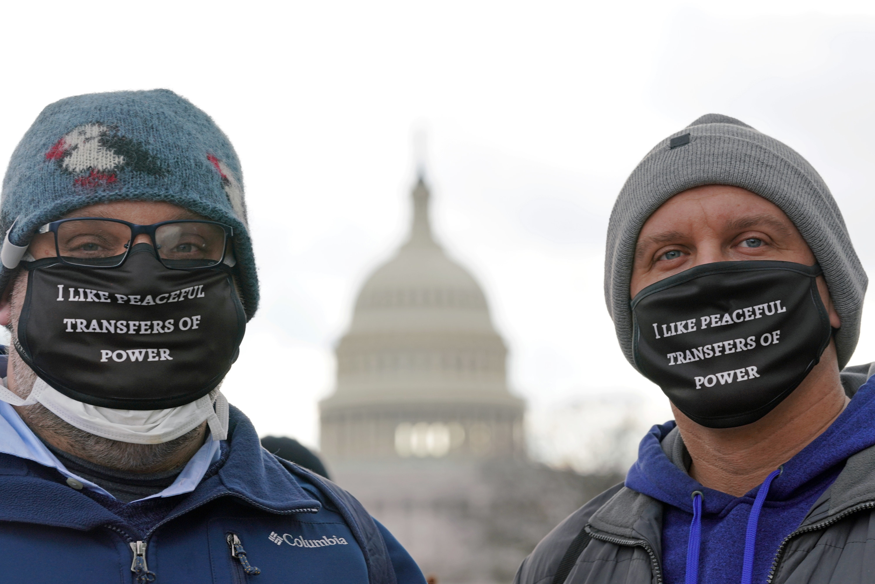 People wearing masks reading &quot;I like peaceful transfers of power&quot; pose in front of the U.S. Capitol before the start of the inauguration of U.S. President-elect Joe Biden.