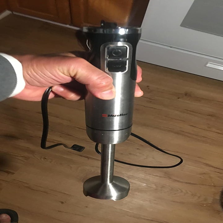 A reviewer photo of a hand holding the immersion blend and attached cord 