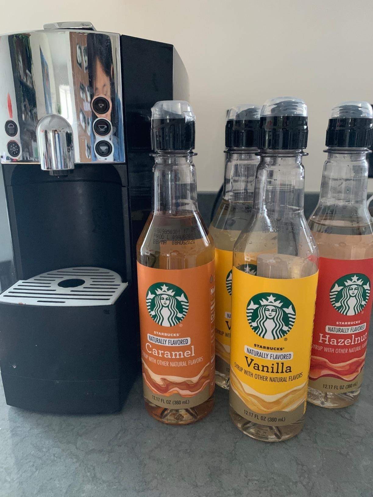Reviewer photo of four bottles of Starbucks flavored syrups