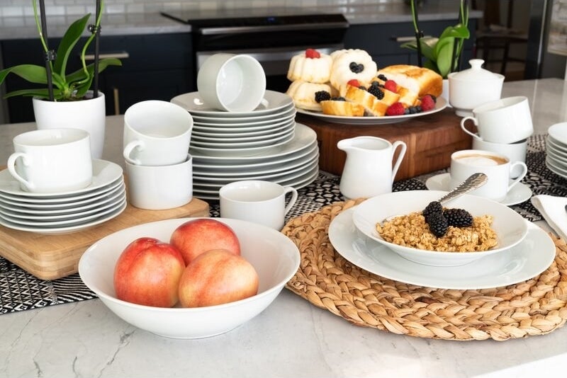 a white circular dinnerware set that is holding food on a counter