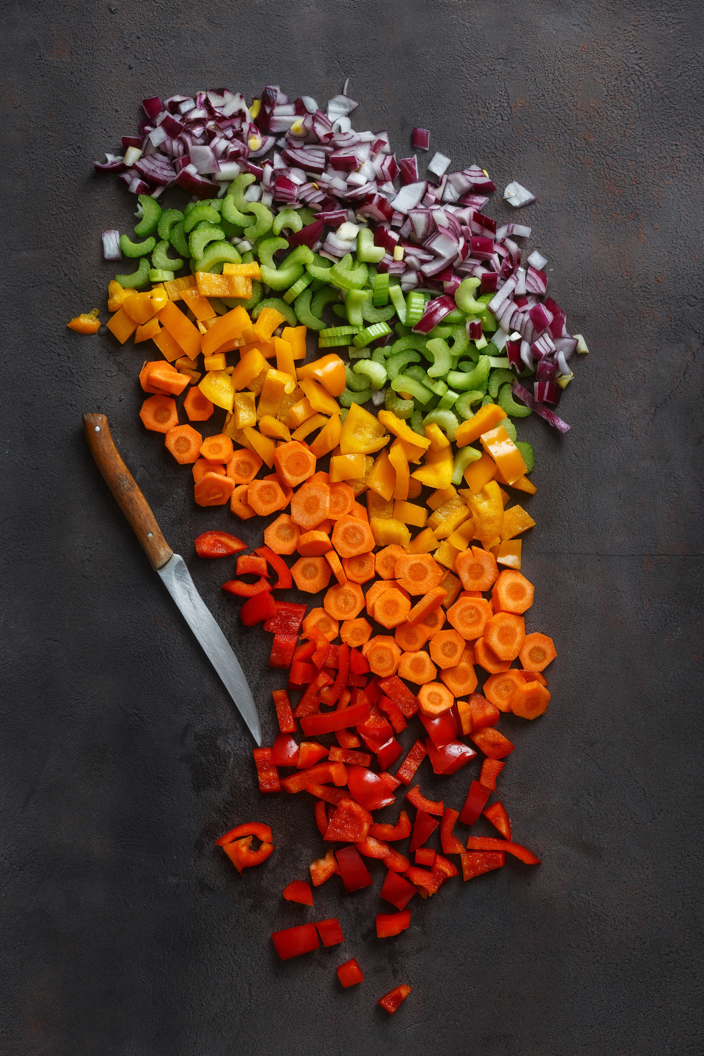 Evenly cut carrots, peppers, onions, and cucumbers