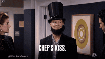 A GIF of someone putting kissing their fingers and saying chef&#x27;s kiss