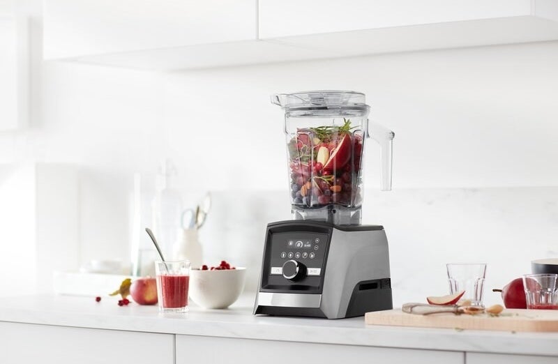 a silver and black vitamix blender holding fruit