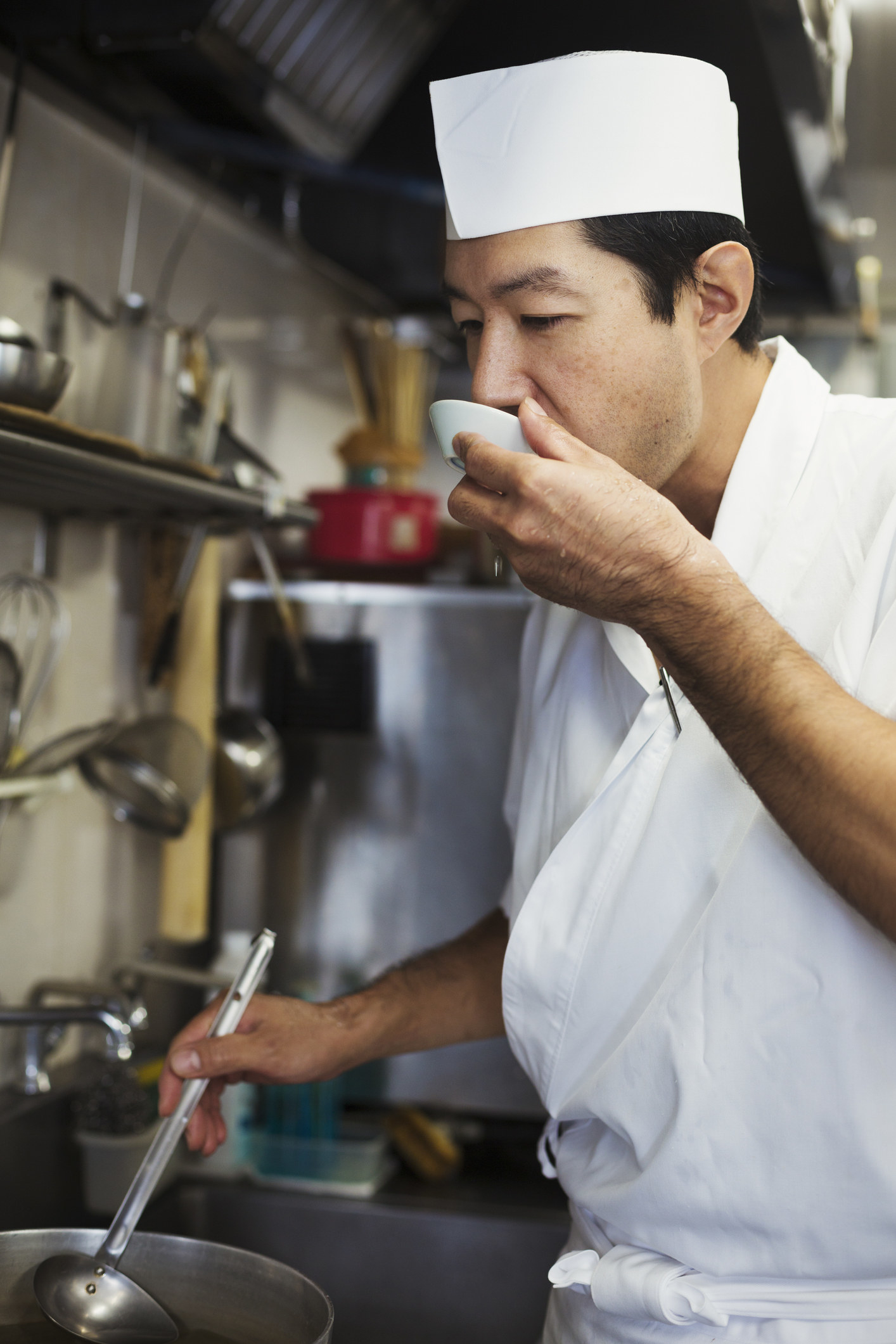 Chef working in the kitchen of a Japanese sushi restaurant, tasting food