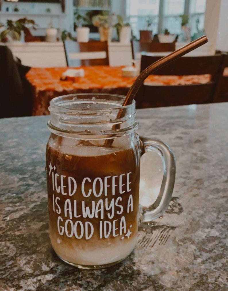 a glass mason jar with a handle a white sticker that says &quot;coffee is always a good idea&quot;