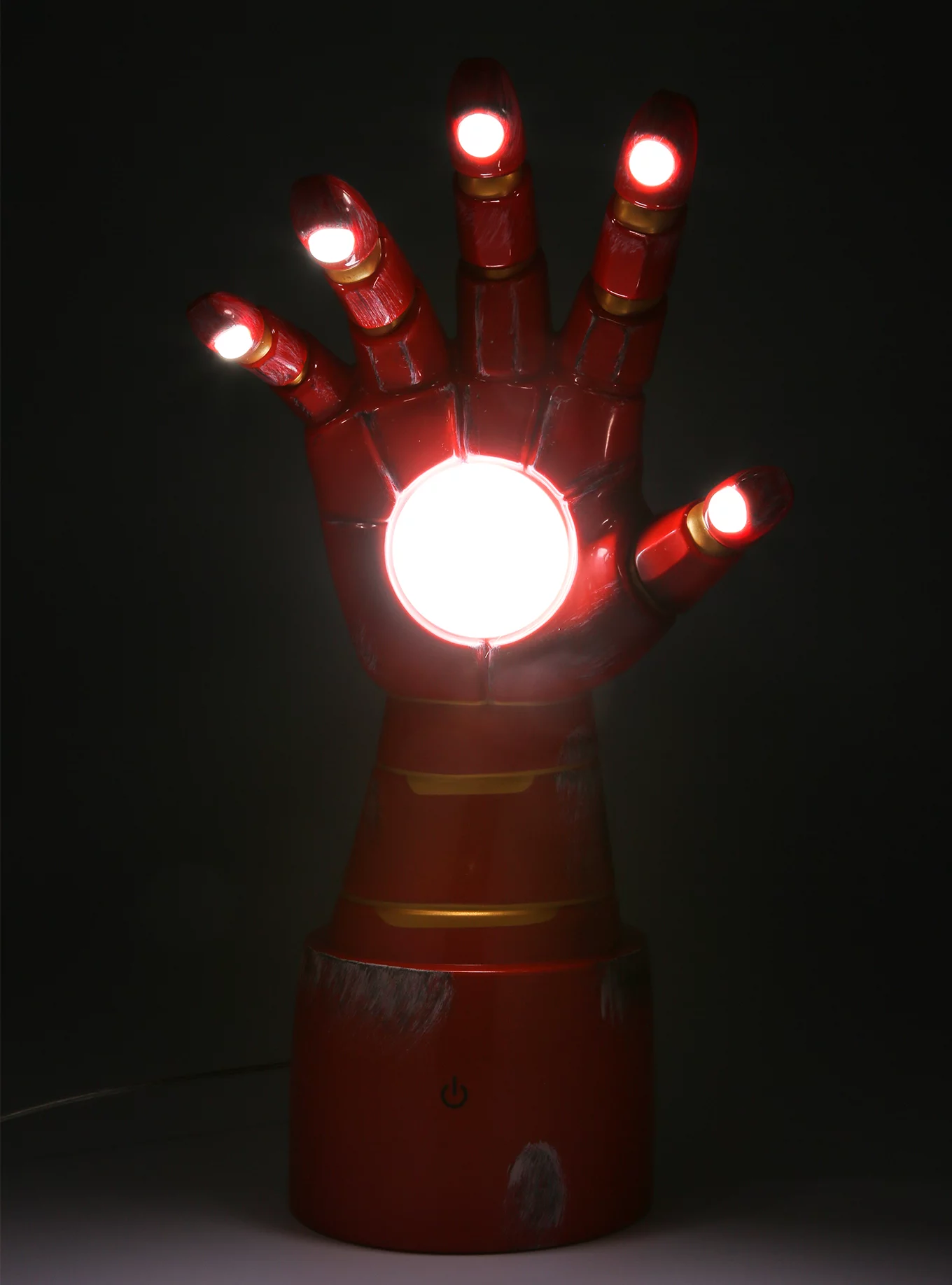 lamp shaped like iron man glove with glowing lights in the palm and fingers