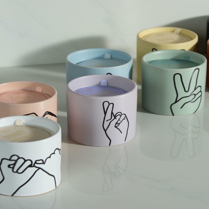 six different paddy wax candled with different hand gestures on them